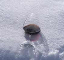 uma vinho vidro é sentado dentro a neve foto