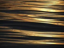 dourado Sol raios reflexão em a mar às pôr do sol foto