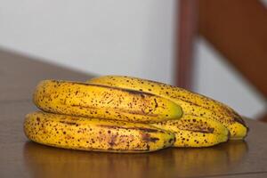 maduro banana grupo com Sombrio pontos em mesa 5 foto