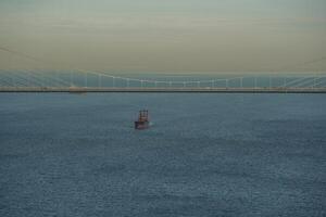 uma navio passagem debaixo yavuz sultão selim ponte sobre a bósforo e garipício Vila, Istambul, peru. foto