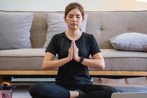 saudável jovem mulher fazendo respiração exercícios às lar, lindo mulher meditando às casa com olhos fechado, praticando ioga, fazendo pranayama técnicas atenção meditação conceito foto