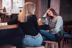 foto enfraquecida de melhores amigos tendo encontro em um café ou restaurante. lindas garotas conversando ou se comunicando enquanto bebem café