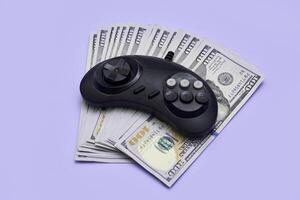 uma vídeo jogos controlador e dinheiro em uma azul fundo foto