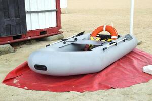 inflável resgate barco. cinzento inflável barco em a de praia dentro a areia foto