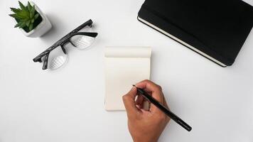 área de trabalho escrivaninha com cadernos, canetas, copos, plantas, e café em branco fundo foto