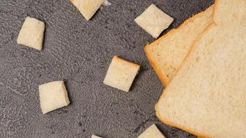 fatiado pão isolado em cinzento fundo. pão cortar para dentro pequeno quadrados foto