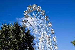 branco ferris roda contra a azul céu. ferris roda dentro a parque foto