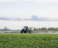 trator com uma spray dispositivo para finamente disperso fertilizante. foto