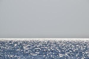 mar linha do a horizonte. mar e céu. a ondas e brilho do a Sol estão refletido a partir de a ondas do a mar. seascape. foto