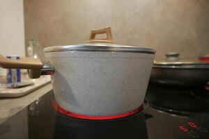 cozinhando panela em elétrico forno, elétrico fogão é aquecido para vermelho. foto