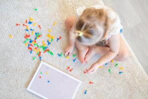 bonita pequeno menina jogando com cogumelo unha mosaico às lar. passatempo e lazer Tempo foto