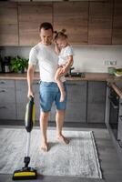 pai com dele filha em dele mãos aspirar a chão dentro a moderno casa cozinha foto