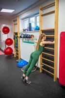 desportivo jovem mulher fazendo exercício às academia. foto