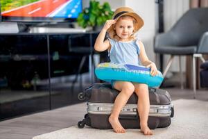 pequeno menina com mala de viagem Bagagem bagagem e inflável vida bóia pronto para ir para viajando em período de férias foto