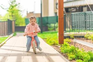 pequeno menina equitação Saldo bicicleta dentro a pátio do a residência dentro Praga, Europa foto