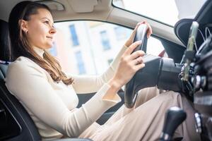 feliz mulher dirigindo uma carro e sorridente. fofa jovem sucesso feliz morena mulher é dirigindo uma carro. retrato do feliz fêmea motorista direção carro. foto