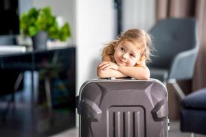 pequeno menina com mala de viagem Bagagem bagagem pronto para ir para viajando em período de férias foto