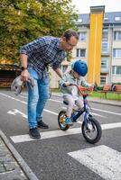 feliz pai ensina criança filha para passeio público bicicleta em 1 do tráfego Parque infantil dentro Praga, tcheco república, Europa foto