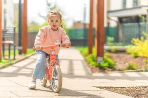 pequeno menina equitação Saldo bicicleta dentro a pátio do a residência dentro Praga, Europa foto