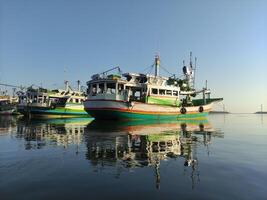 colorida pescaria barcos ancorado dentro a Porto em paiton de praia Indonésia foto