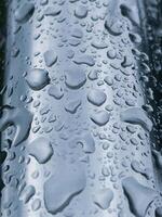 pingos de chuva em a metálico superfície dentro chuvoso dias foto
