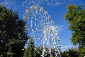 branco ferris roda contra a azul céu. ferris roda dentro a parque foto