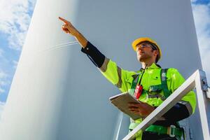 engenheiro inspeciona vento turbina às vento Fazenda para manutenção foto