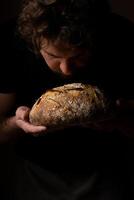 atraente jovem caucasiano chefe de cozinha posando com branco fermento pão. foto