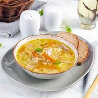 fresco frango sopa com legumes e estelino massa dentro uma tigela com cenoura e salsinha. foto