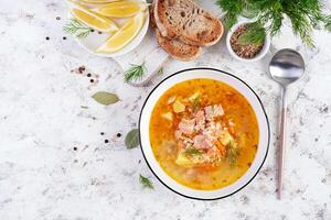 peixe sopa com salmão, legumes e arroz dentro branco tigela. salmão sopa. topo visualizar, plano deitar foto