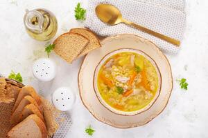 fresco frango sopa com legumes e estelino massa dentro uma tigela com cenoura e salsinha. topo visualizar, plano deitar foto