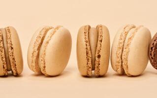 chocolate macarons em uma bege fundo, sobremesa foto