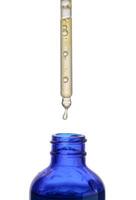 uma vidro azul garrafa com uma conta-gotas em uma branco isolado fundo foto