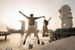 Merlion fonte dentro frente do a marina baía areias com jovem ásia casal do amor turista. foto