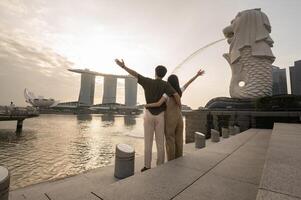 Merlion fonte dentro frente do a marina baía areias com jovem ásia casal do amor turista. foto