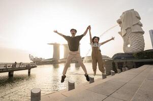 Merlion fonte dentro frente do a marina baía areias com jovem ásia casal do amor turista. foto