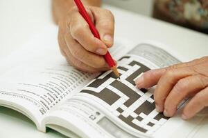 idosos mulher jogando sudoku enigma jogos para tratamento demência prevenção e alzheimer doença. foto