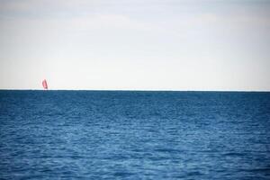 longe Navegando barco a vela morgana efeito em a ótimo azul mar, a □ Gentil brisa sopro dentro a velas Como a cidade ruídos estão longe ausente. foto