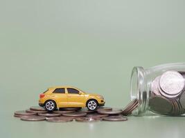 brinquedo carro e pilha do moedas. a conceito do salvando dinheiro e gerir para sucesso transporte o negócio foto