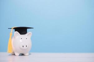 porquinho banco com graduação chapéu. a conceito do salvando dinheiro para Educação, aluna empréstimo, bolsa de estudos, taxa escolar honorários dentro futuro foto