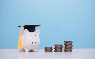 porquinho banco com graduação chapéu e pilha do moedas. a conceito do salvando dinheiro para Educação, aluna empréstimo, bolsa de estudos, taxa escolar honorários dentro futuro foto