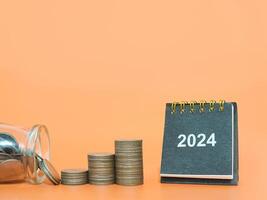 2024 escrivaninha calendário e pilha do moedas. a conceito do o negócio crescimento, financeiro investimento, mercado estoque, lucro retornar, dividendo e o negócio fundo dentro ano 2024 foto
