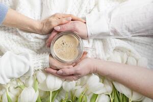 quatro mãos aguarde 1 do em forma de coração café xícara, branco tulipas foto