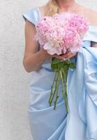 noiva dentro uma azul Casamento vestir com uma ramalhete do Rosa peônias, pastel paraíso foto