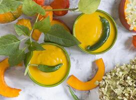 abóbora purê sopa dentro verde taças em cinzento cimento fundo, colorida comida, foto