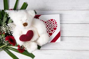 dia dos namorados dia presente, Urso de pelúcia Urso com uma coração, uma caixa do bombons e uma ramalhete foto