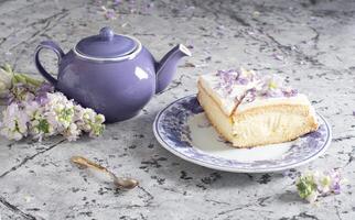 ainda vida com Preto chá e queijo bolo, Primavera buquê, delicado lilás flores foto