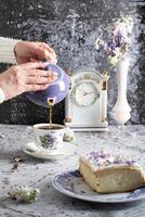 ainda vida com Preto chá e queijo bolo, Primavera buquê, delicado lilás flores foto
