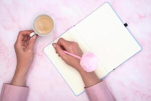 a menina calcula dentro uma caderno a calorias do uma rosquinha e uma copo do café foto