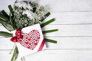 dia dos namorados dia presente, vermelho coração praliné caixa e flor ramalhete em branco mesa foto